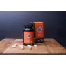 Een fles en doos met het opschrift "MindScopic - MOODMASTER™ capsules (50 stuks)" met capsules verspreid over een houten oppervlak, tegen een donkere achtergrond. miniatuur