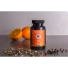 Een fles MindScopic - MOODMASTER™ capsules (50 stuks) staat op het aanrecht met een sinaasappel, een sinaasappelhelft en verspreide peperkorrels en gedroogde kruiden. miniatuur