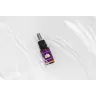 Een klein bruin sprayflesje met de tekst "MindScopic - SLEEPWELL SPRAY met melatonine (15ml)" met een paars en gouden ontwerp staat op een wit, waterig oppervlak. miniatuur