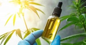 een persoon in blauwe handschoenen die een fles cbd vasthoudt.